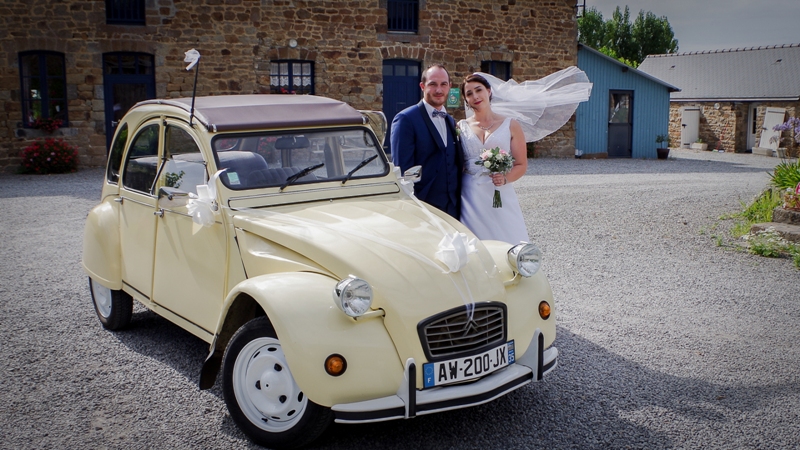 Mariés devant une 2CV ancienne en Bretagne